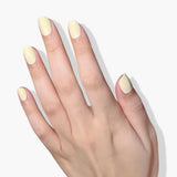 A hand with neatly manicured nails painted in Buttercup, a pastel yellow creme by LONDONTOWN, shown against a white background. This vegan UV/LED Gel Color adds a touch of elegance and shine.